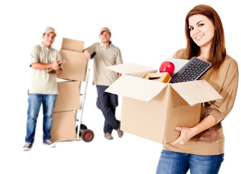 Professional helper moving office furniture during a removals service